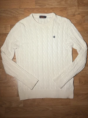 Vit kabelstickad tröja från Morris - Säljer en vit kabelstickad tröja från Morris med rund halsringning och diskret logga på bröstet. Tröjan har långa ärmar och ribbade muddar vid ärmslut och nederkant. Perfekt för lager-på-lager under höst och vinter. Är storlek M men upplevs som S och passar perfekt på dig som oftast har S. Priset kan diskuteras så hör gärna av dig med prisförslag eller frågor.