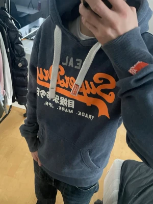 Vintage 2000s Superdry Hoodie JPN (Nyskick) - Säljer nu denna sjukt snygga vintage 2000s Superdry hoodie med en perfekt passform🙌 Säljs ej längre i butik och är därav mycket eftertraktad😊 Endast använd 2 gånger och är fortfarande i nyskick🤩 Skriv vid funderingar 📲