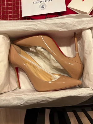 Louboutin Kate - Beiga Louboutin Kate klackar! Aldrig använda endast testade hemma vilket har gett några små repor som syns på bild. Kvitto finns, original förpackning och påsar medkommer!
