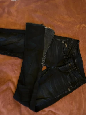 Mörkblå G-Star Raw jeans skinny fit - Säljer ett par mörkblå skinny jeans från G-Star Raw med snygga slitningar och klassiska fem fickor. Jeansen har silverfärgade detaljer, logga på myntfickan och smala ben. Perfekta för dig som gillar en tajt passform och stilren look.