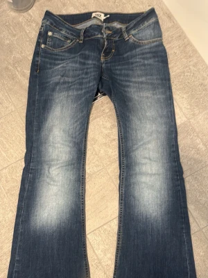 Blå bootcut jeans Blaze lager 157 - Snygga blå jeans från 157 med bootcut-modell och klassisk femficksdesign. Jeansen har ljusa slitningar framtill och kontrastsömmar som ger en cool look. Tillverkade i jeansmaterial med normal passform och låg midja. Säljer eftersom att de är lite för korta för mig. De är i strl M short men de är är nedtagna så de är lite längre. Skulle passa nån som e cirka 165 perfekt. Jag älskar verkligen jeansen men tyvär är de för korta de är därför jag säljer de. De är använda max 5 gånger. Inga slitningar.