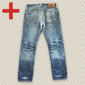 RRL Low Straight Dry Selvedge  - Ett par low-rise RRL Straight Selvedge jeans med sjuk patina! Storlek 29/30 (se mått nedan). Bra skick, har blivit lagade i grenen och slitningar över båda benöppningarna. Skriv om du har frågor!  Mått: Storlek på tag – 29/30, Midja – 40.5 cm, Lår – 28.5 cm, Innersöm – 78.5 cm, Längd – 99 cm, Benöppning – 19 cm