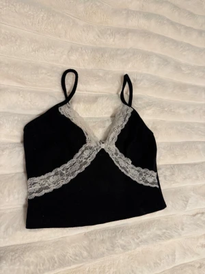 y2k topp med spets - Svart kort top med vit spets och rosett🤍 Köpte på Plick för flera år sedan och vet ej märke men det står storlek S