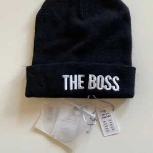 Svart mössa med tryck  - Svart mössa med tryck. Aldrig använd med prislapp.