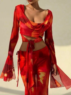 Röd långkjol o topp med knyt och mönster - Säljer en  långkjol o topp i rött med orange och gula inslag. Kjolen har ett snyggt knyt i midjan och ett flowigt, figurnära fall. Materialet är lätt och luftig , perfekt för varma dagar. Perfekt för sommaren