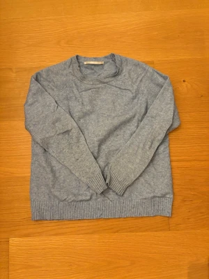 Ljusblå stickad tröja från ONLY - Mysig ljusblå stickad tröja från ONLY i storlek S. Tröjan har rund halsringning, ribbade muddar vid ärmslut och nederkant samt lång ärm. Perfekt för lager på lager under kyliga dagar. 50% Viskos, 27% Nilon, 23% Polyester.