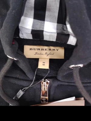 Burberry zipper svart  - Som ny helt svart med designer på luvan knappast använd iga håll IgA slitna tecken ele platser bra zipp