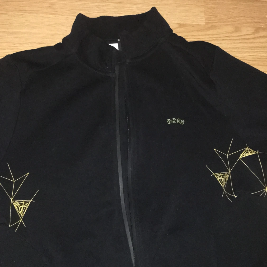Svart vindjacka från BOSS med gul brodyr