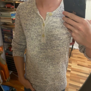 Henley - Säljer en vit och blå stickad henleytröja från Esprit med snyggt melerat mönster. Tröjan har lång ärm, rund hals och tre knappar framtill som ger en chill look. Köpt på second hand, men har aldrig använt. Helt felfri. Kan tänka mig gå ner i pris vid snabb affär. 