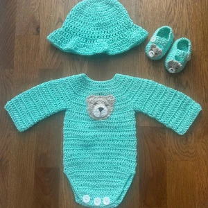 Virkat Babyset 0-3 månader - Body, solhatt & tossar - Ett babyset i superfint turkost bomull/akrylgarn. Virkad björndekal som gör det ännu gulligare 🩵