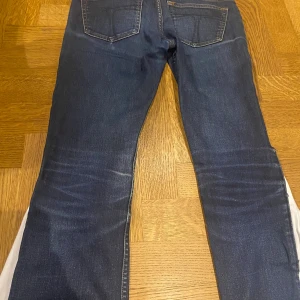Mörkblå jeans med vit spets - 96 cm innerbenslängd - YTTERLIGARE INFO FINNS PÅ BILDERNA!Supergulliga mörkblå jeans med vit spets nertill. Jeansen var skinny från början, därav har vi ändrat modell till bootcut med hjälp av vitt tyg. Vi har även förlängt jeansen med vit spets, från 73 cm i innerbenslängd till 96!!💙  Jeansen är i bra skick, enda att anmärka på är märken som gjorts pga hur jeansen legat. Därav lite ”ränder” och en liten fläck på ena bakfickan. Men detta tycker vi endast bidrar till än ännu mer cool och unik design! 
