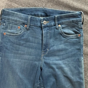 Blå skinny jeans från &Denim - Säljer ett par blå skinny jeans från &Denim i storlek 28/30. De har regular waist, klassisk femficksdesign och är gjorda i mjukt denimtyg. Perfekta för dig som gillar en tight passform och enkel stil.