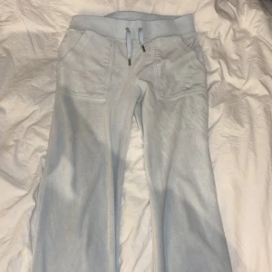 Ljusblå mjukisbyxor Juicy Couture XXS - Supermysiga ljusblå mjukisbyxor från Juicy Couture i storlek XXS. Byxorna har snörning i midjan, två fickor fram och två bak med knappdetaljer. Mjukt material och klassisk Juicy Couture-logga broderad på ena fickan. Har andvänt 2 gånger ungefär.