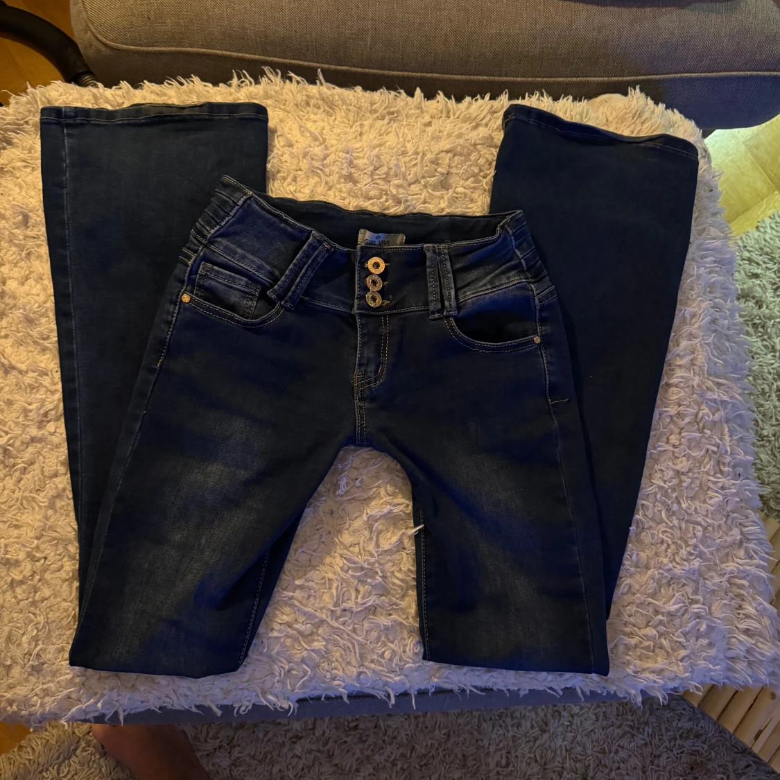 Mörkblå lågmidjade/utsvängda jeans med tre knappar