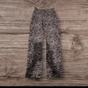 Zebramönstrade wide manchesterbyxor - Säljer ett par sjukt snygga manchesterbyxor med zebramönster i brunt och vitt från RW. Byxorna har breda ben och klassisk femficksdesign. Perfekt för dig som vill sticka ut med coola mönster och skön passform.