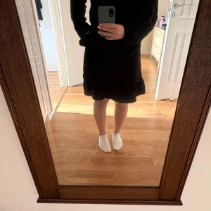 Svart omlottkjol med volang - En svart kort omlottkjol med volangkant nertill och knyt i midjan. Inte använd så mycket så i fint skick. Normal i storleken. Djur och rökfritt hem. 