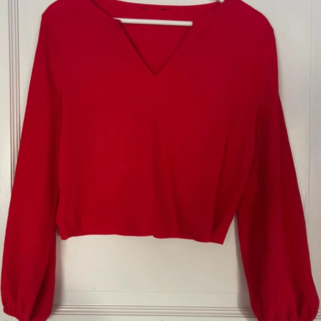 Röd blus med v-ringning och ballongärm