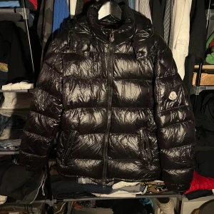 Svart Moncler pufferjacka med huva - Säljer en äkta moncler jacka med två lagade hål där av priset. Pris kan diskuteras vid snabb affär
