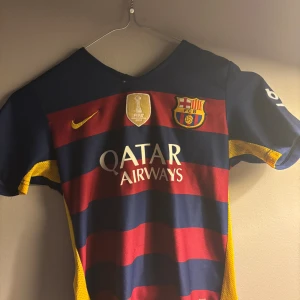 FC Barcelona Neymar Jr matchtröja - Säljer en officiell FC Barcelona fotbollströja från Nike med Neymar Jr och nummer 11 på ryggen. Tröjan har breda blå och röda ränder, gula detaljer och klubbmärke på bröstet. Qatar Airways och UNICEF-loggor. Tillverkad i lätt och ventilerande material.