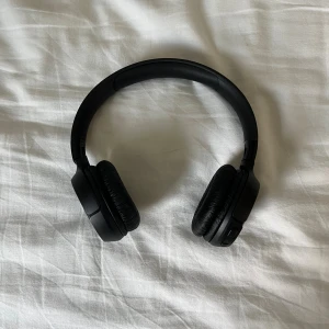 JBL Tune 520BT - JBL Tune 510BT trådlösa on-ear hörlurar i svart. Med koppling till Bluetooth. Bluetooth namn: ”JBL TUNE520BT”. Snygg design, bekväma öronkuddar och tydliga knappar för volym och styrning. Hörlurarna är i mycket gott skick utan synligt slitage. Perfekt för musik, samtal och vardagsbruk. OBS! Ingen laddare ingår! 