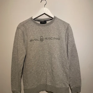 Grå Sail Racing sweatshirt S - Snygg grå sweatshirt från Sail Racing i storlek small. Tröjan har rund hals, lång ärm och tryckt logga på bröstet. 