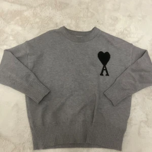 Ami Paris tröja  - Fin Ami Paris sweatshirt Grå i storlek S. Bekväm passform och mjukt material, med det ikoniska hjärtloggan. I topp skick utan fläckar eller hål.