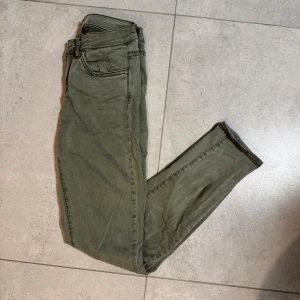 Olivgröna skinny jeans - Gina tricot stl 34 (Xs) - Snygga olivgröna skinny jeans från g perfect jeans med klassisk femficksdesign och dragkedja. Jeansen har smal passform och normal midja, perfekta för en stilren och avslappnad look.