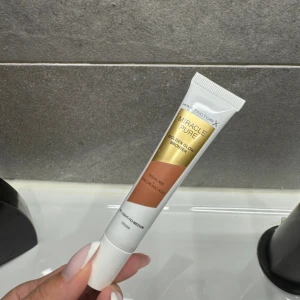 Max Factor Miracle Pure Golden Glow Bronzer - Max Factor Miracle Pure Golden Glow Bronzer i tubformat. Färgen är en varm, gyllene brun som ger en naturlig solkysst look. Innehåller squalane och hyaluronsyra, vegansk formula. Perfekt för att skapa glow och definiera ansiktet.