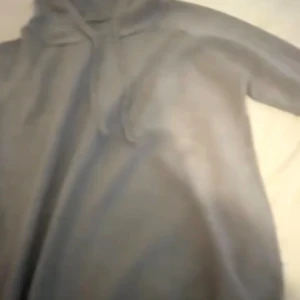 Grå hoodie med huva och snörning - En enkel och stilren grå hoodie med huva och snörning. Perfekt för dig som gillar en avslappnad look. Tröjan har långa ärmar och en klassisk passform som funkar till det mesta.