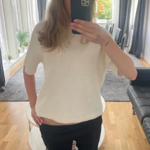 Vit stickad tröja  - Superskön vit stickad tröja från Gina med korta ärmar och rund hals. Tröjan har en loose passform och ribbade detaljer vid hals, ärmslut och nederkant. Perfekt för lager-på-lager och chill stil under vår och sommar. Jätte skön och mysig för vintern💓