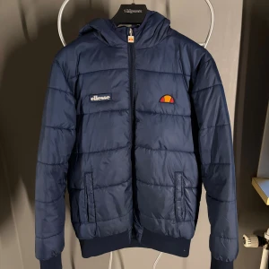 Ellesse Vinterjacka Mörkblå - En snygg mörkblå Ellesse vinterjacka. Använd en två gånger där av det fina skicket.                            Herrsorlek S
