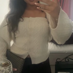 Vit stickad armlös topp med en kortkofta intill - Säljer en vit stickad armlös topp med en kort kofta till med långa ärmar. Toppen har ett diskret mönster och knappar framtill. Perfekt för dig som gillar en mjuk och cozy vibe med lite extra stil. Passar till både jeans och kjol. Toppen är i storlek L och koftan är i storlek M. (Jag har på mig S/M toppen var lite för stor för mig, gillar du att ha på dig lite mer oversize hade denna toppen varit perfekt för dig, för dig som bär L/M hade denna även suttit perfekt)! 💕199:- för både topp och kofta