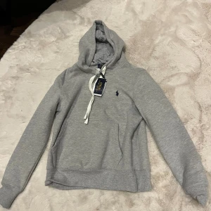 Grå hoodie från Polo Ralph Lauren - Helt ny snygg grå hoodie, säljer på grund av att den är för liten. Passar storlek S, kom med prisförslag