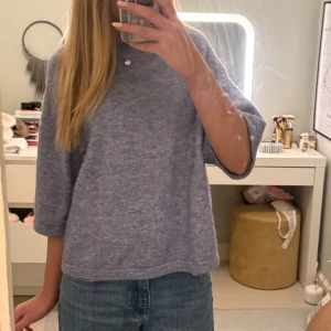 Ljusblå stickad tröja med trekvartsärm - Säljer en ljusblå stickad tröja med avslappnad passform och trekvartsärmar. Mjuk och skön, perfekt för att chilla eller hänga med kompisar. Enkel design som funkar till jeans eller andra favoritplagg.