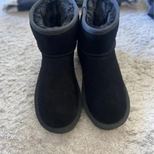 Svarta boots med pälsfoder - Mysiga svarta boots med rund tå och platt sula. Utsidan är i mjuk mocka och insidan har ett fluffigt pälsfoder som håller fötterna varma. Perfekta för kalla dagar och har en enkel, stilren design som passar till det mesta.  Har använts ett par gånger bara så de är i nyskick. Storlek 37 och vattentäta av märket Duffy.  Säljer dom för 200:-