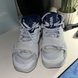 Nike Jordan sneakers med färgglad häl - Nike Jordan sneakers med vit ovandel i skinn och mesh, snörning och kardborreband. Hälen har ett färgstarkt grafiskt mönster och Jumpman-logga. Sulan är vit med rosa detaljer undertill. Perfekta för dig som vill sticka ut med coola detaljer och bekväm passform. Storlek 40,5/41
