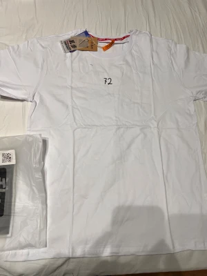 Vit Daft Punk t-shirt med tryck - Vit t-shirt från Daft Punk i bomull med svart tryck. Framsidan har siffran 72 och texten 'Don't' på ärmen. Baksidan har en stor stickman-illustration. Klassisk passform och rund hals. Perfekt för dig som gillar unik och edgy streetstyle.