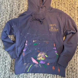 Gallery Dept. Hoodie - Säljer en trendig mörkblå hoodie från Gallery Dept med färgstänk. En tjock och varm hoodie perfekt till vintern. Jag tycker att hoodien passar helt perfekt! Den är sparsamt använd bara några få gånger 9/10 skick. Säljer den då den inte kommer till användning längre. Pris kan självklart diskuteras! 