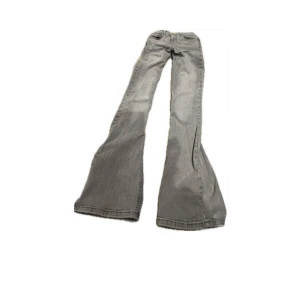 Grå bootcut jeans med låg midja - Snygga grå jeans med bootcut och låg midja. Modellen har klassisk femficksdesign och är tillverkad i mjukt jeanstyg. Perfekt för dig som gillar retrovibbar och vill ha ett statement-plagg med breda ben.