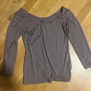 Grå långärmad Heattech topp - Säljer en grå långärmad topp från Heattech med rundad halsringning. Tunn och smidig modell som passar perfekt att ha som lager under andra plagg. Materialet är mjukt och följsamt, vilket gör den bekväm att bära hela dagen.