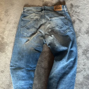 Replay wallys ljusblå jeans - Säljer ett par ljusblå jeans från Replay med klassisk femficksdesign och snygga slitningar. Jeansen har raka ben och normal/slim passform, samt coola detaljer på bakfickorna. Perfekta för dig som gillar en avslappnad stil. Helt nya.