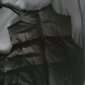 Svart dunväst med hög krage - Dunväst från H&M, anväts få antal gånger.