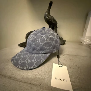 Gucci Navy Denim Cap  - Snygg blå keps från Gucci med ikoniskt GG-mönster över hela kepsen, Dustbag ingår för kepsen. Perfekt accessoar för att lyfta din streetwear-look. För speciella beställningar skriv bara. Mvh Trend collective.