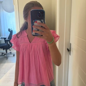 Rosa blus med volangärmar från Gina Tricot - Säljer en söt rosa blus från Gina Tricot med volangärmar och v-ringning. Är i storlek 158/164 men sitter som en Xs. Använd mycket få gånger