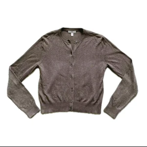 Brun kofta  med knappar - En klassisk brun kofta i mjuk med rund halsringning och knäppning framtill. Långärmad modell med ribbade muddar och nederkant. Perfekt att slänga över en t-shirt eller klänning för extra värme.