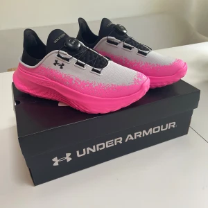 Under Armour SlipSpeed Mega Ripstop - Säljer ett par oanvända Under Armour SlipSpeed Mega Ripstop sneakers i grått och rosa med svart BOA-snörning. Sköna slippers i kombination med bra träningssko..