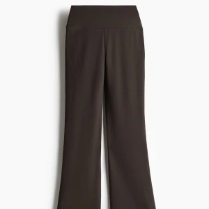 Flared yoga pants - Mörkbruna byxor från Move H&M med bred resår i midjan och utsvängda ben. Tillverkade i ett stretchigt syntetmaterial som ger en skön passform. Perfekta för dig som gillar en avslappnad och trendig look.