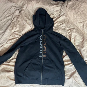 Hugo Boss tröja med dragkedja - Svart hoodie från Hugo Boss. Typ nyskick, inga skador eller liknande.