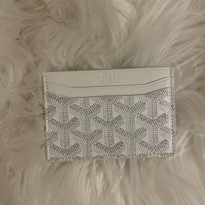 Vit Goy4rd plånbok med mönster - Supersnygg vit plånbok från Goy4rd med deras ikoniska grafiska mönster. Slimmad design med flera kortfack, perfekt för dig som vill ha något stilrent och lyxigt. Tillverkad i skinn och levereras med originalbox och kvitto.