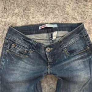 Blå bootcut jeans från Only - Snygga blå jeans från Only i bootcut-modell med slitningar och ljusare partier. Klassisk femficksdesign, gylf med knapp och dragkedja samt kontrastsömmar. Säljer för att dom är för små. Passar S, skriv om ni har frågor angående priset, storleken eller något annat💕